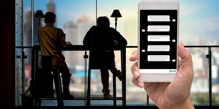 Female hand holding mobile phone showing the chat message before Female hand holding mobile phone showing the chat message before place the order over the Stock market chart,Closeup Stock market exchange data on LED display, business trading and technology concept